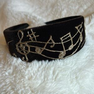 Brown velvet hand painted hair band with gold dimensional paint. Melody/ music.